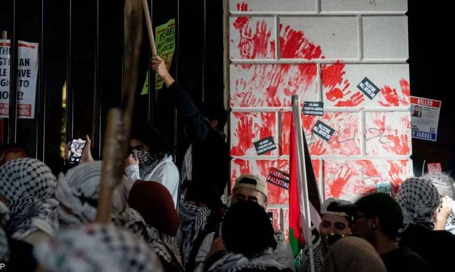 متظاهرون يلطخون أبواب البيت الأبيض بالطلاء الأحمر وهتافات تدين بايدن