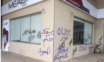 شعارات على واجهة أحد فروع المصارف في صور